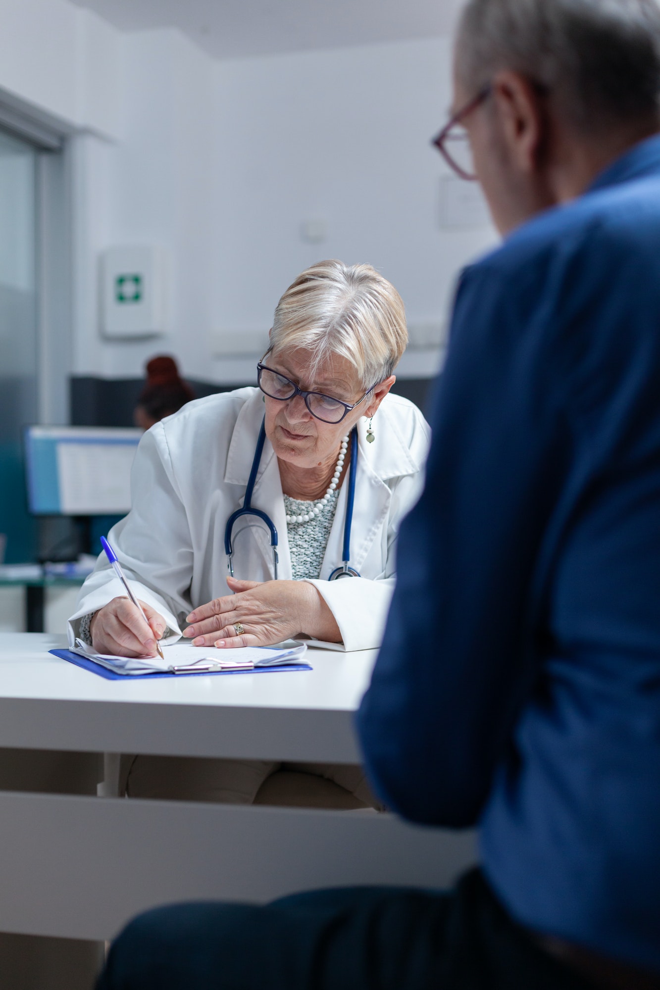 Close up of medic signing medical papers for prescription treatment at checkup visit