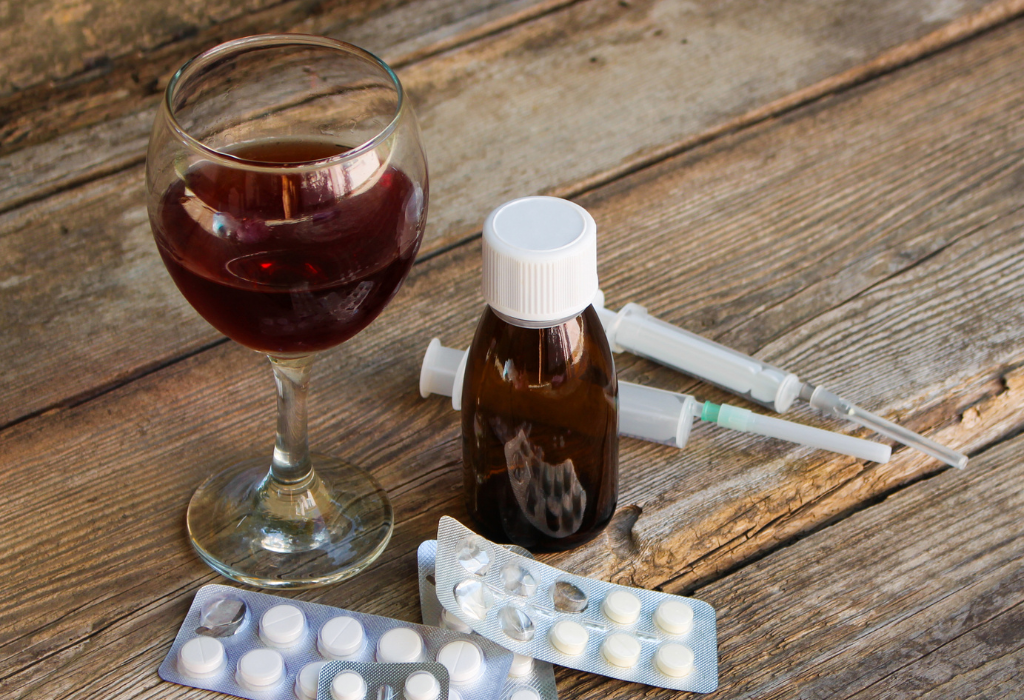Fluconazole and alcohol interaction with medication and wine glass on wooden table
