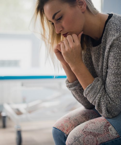 A woman sit on a hospital bed with anxiety. She was afraid of despair What she wants now is faith