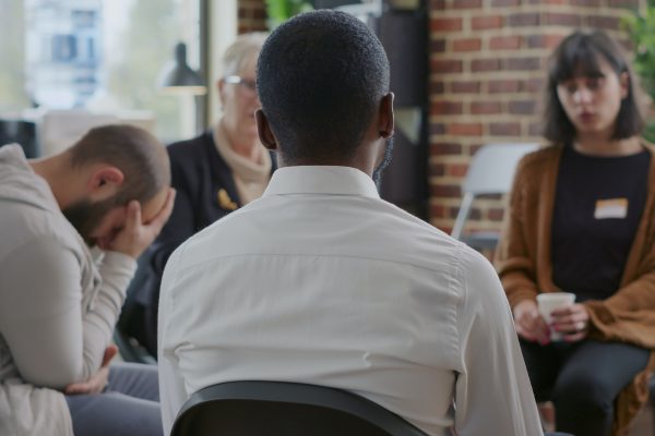 Close up of african american man discussing alcohol addiction at aa therapy session